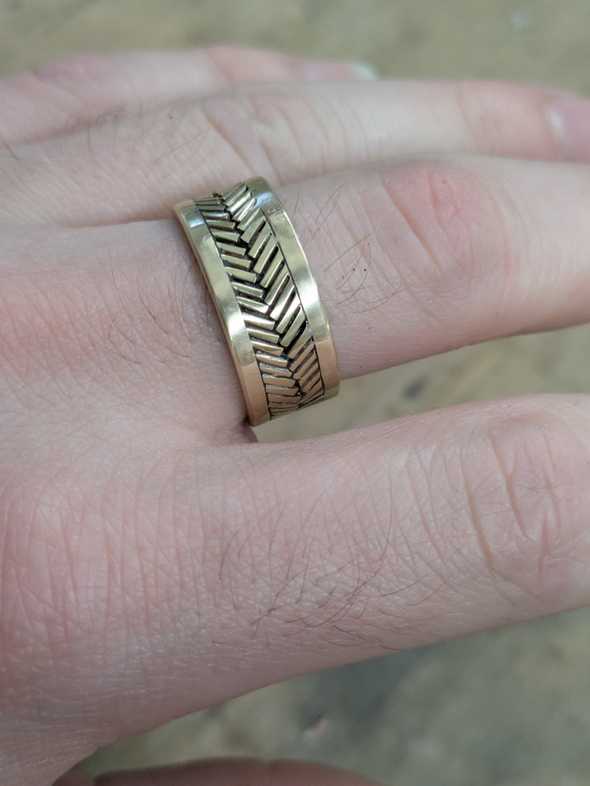 a brass ring with a herringbone pattern